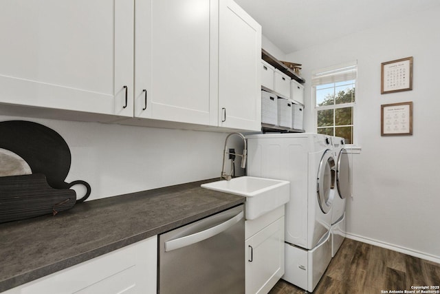 laundry room with dark wood-type flooring, a sink, baseboards, cabinet space, and washer and clothes dryer