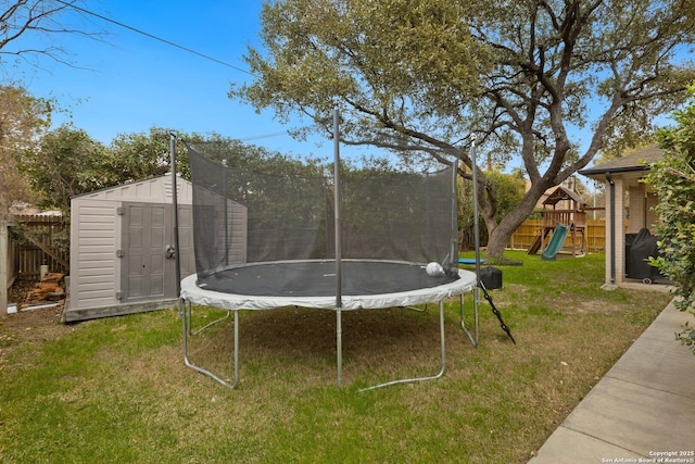 view of yard with a storage shed, a fenced backyard, a trampoline, an outdoor structure, and a playground