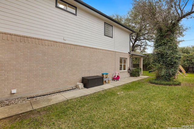 view of property exterior featuring a yard and brick siding