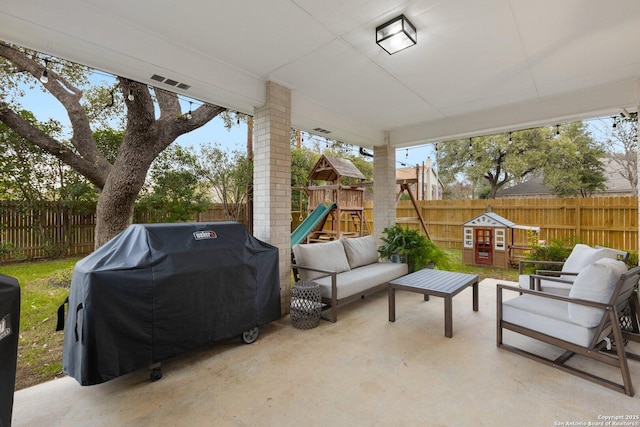 view of patio with an outdoor hangout area, area for grilling, a fenced backyard, and a playground