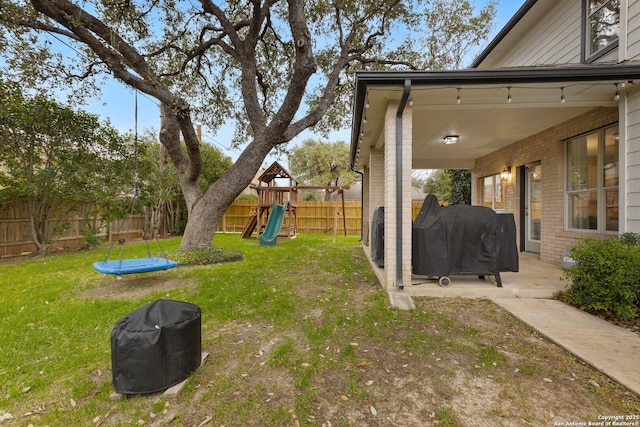 view of yard with a patio area, a playground, and a fenced backyard