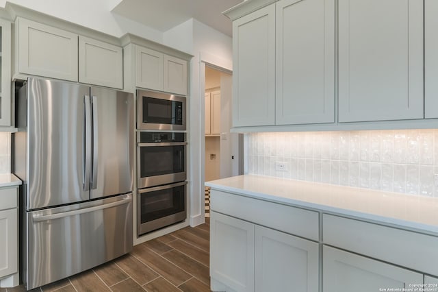 kitchen featuring backsplash, gray cabinetry, and stainless steel appliances