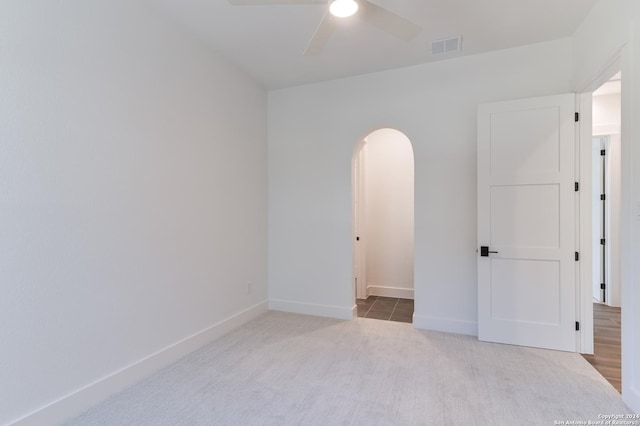 carpeted spare room featuring ceiling fan