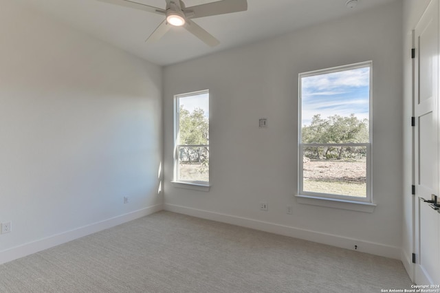 carpeted empty room featuring ceiling fan and plenty of natural light