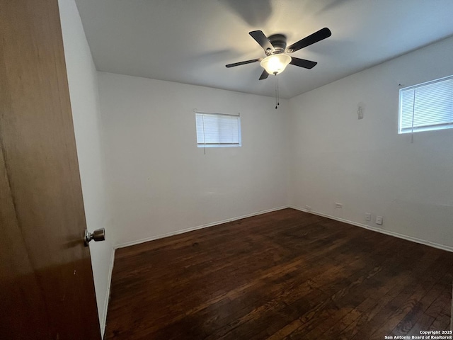 empty room featuring ceiling fan and dark hardwood / wood-style flooring