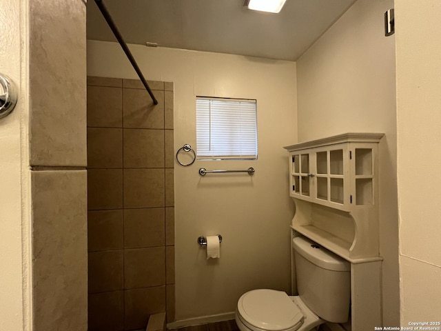 bathroom featuring toilet and tiled shower