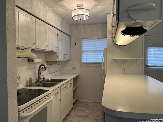 kitchen featuring white cabinets, white range with electric cooktop, decorative backsplash, sink, and range hood