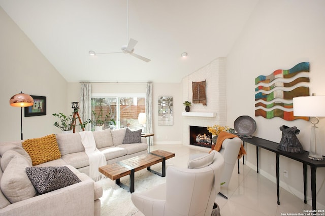 living room with ceiling fan, a large fireplace, light tile patterned floors, and vaulted ceiling