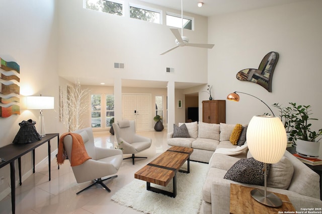 tiled living room featuring ceiling fan and a towering ceiling