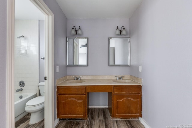 full bathroom with vanity, toilet, tiled shower / bath combo, and hardwood / wood-style flooring