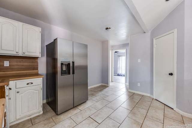 kitchen featuring stainless steel refrigerator with ice dispenser, ceiling fan, white cabinetry, light tile patterned floors, and butcher block counters