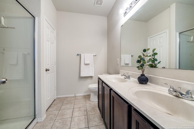 bathroom with vanity, toilet, tile patterned floors, and a shower with shower door