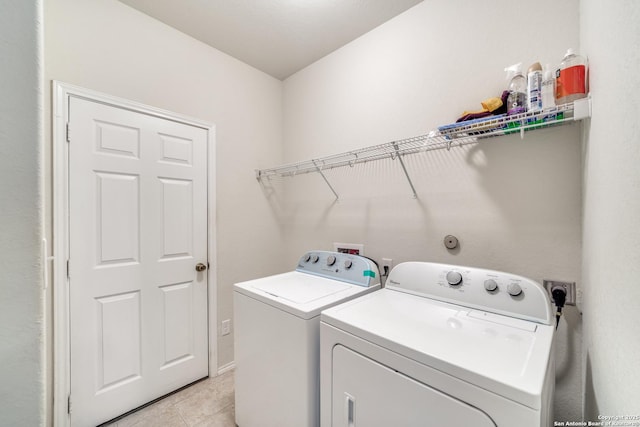 clothes washing area with light tile patterned floors and independent washer and dryer