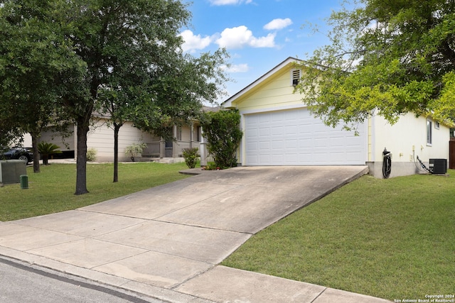 view of front of house featuring a garage, cooling unit, and a front lawn