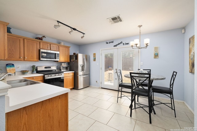 kitchen featuring pendant lighting, appliances with stainless steel finishes, track lighting, sink, and light tile patterned flooring