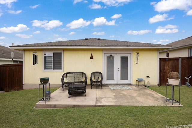 back of house with french doors, a patio, and a lawn