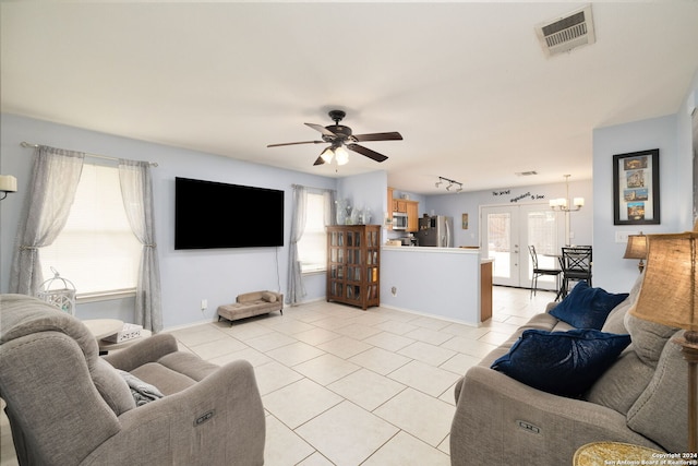 tiled living room with track lighting and ceiling fan with notable chandelier