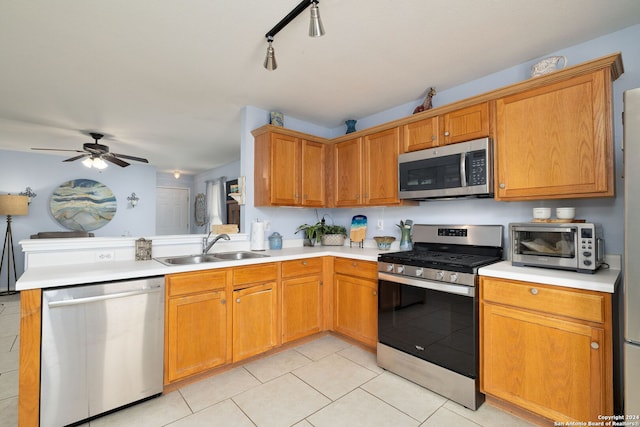 kitchen featuring ceiling fan, rail lighting, light tile patterned floors, sink, and stainless steel appliances