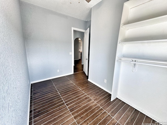 unfurnished bedroom featuring a textured ceiling and ceiling fan