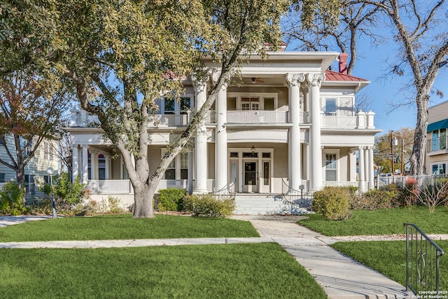 greek revival house with a balcony and a front lawn