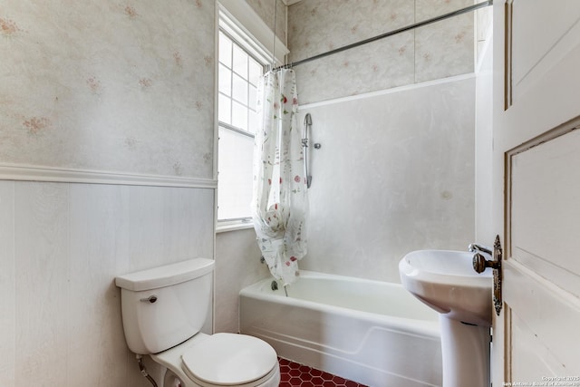 bathroom featuring toilet, a wealth of natural light, shower / tub combo, and tile patterned flooring