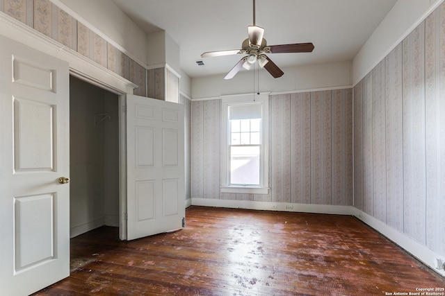 unfurnished bedroom featuring ceiling fan, dark wood-type flooring, and a closet