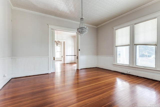 unfurnished room featuring a chandelier, crown molding, and wood-type flooring