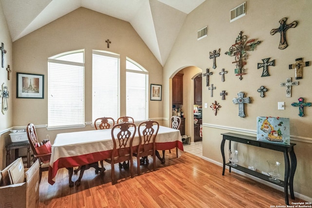 dining room featuring vaulted ceiling and light hardwood / wood-style flooring