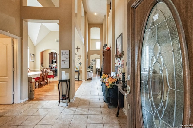 foyer entrance with light tile patterned floors and a high ceiling