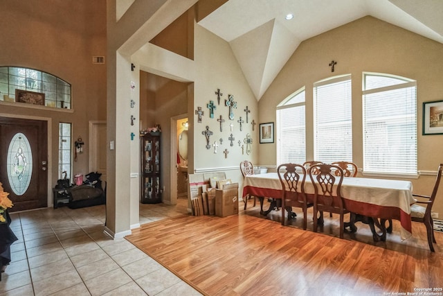 dining area featuring light hardwood / wood-style flooring and high vaulted ceiling