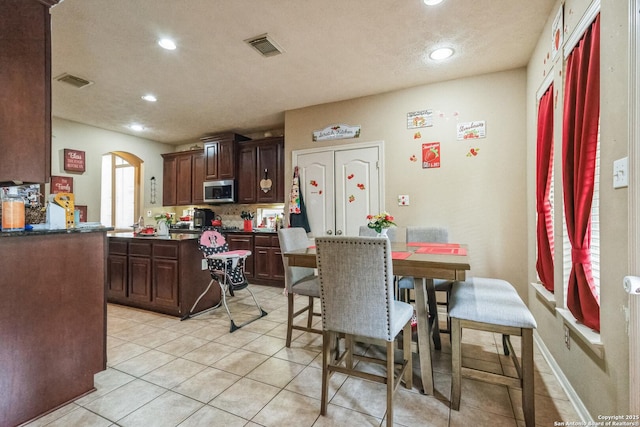 dining room featuring light tile patterned flooring and a textured ceiling