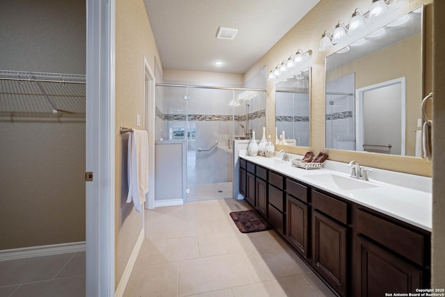 bathroom featuring walk in shower, vanity, and tile patterned flooring