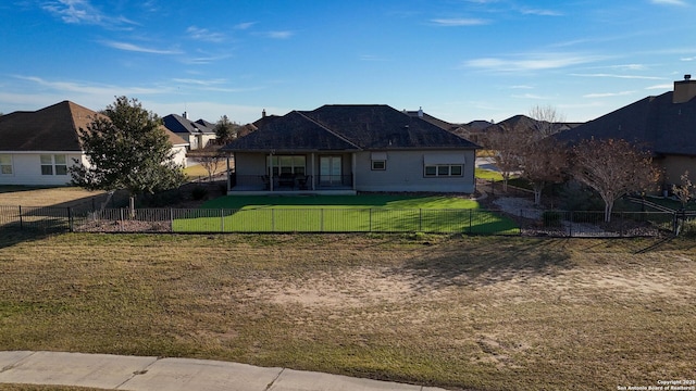 rear view of property featuring a lawn