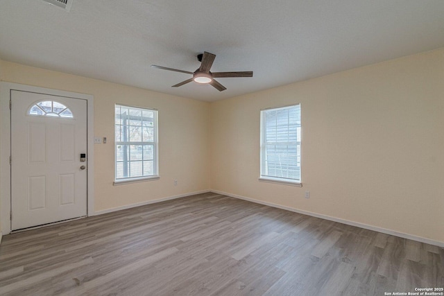 entrance foyer with light wood-type flooring, ceiling fan, and a wealth of natural light