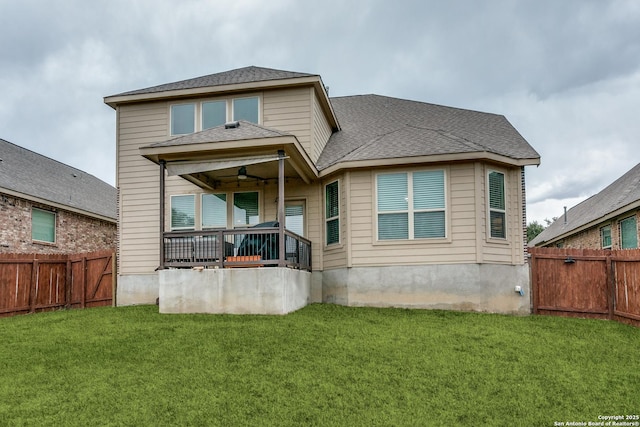 rear view of property with ceiling fan, a lawn, and covered porch