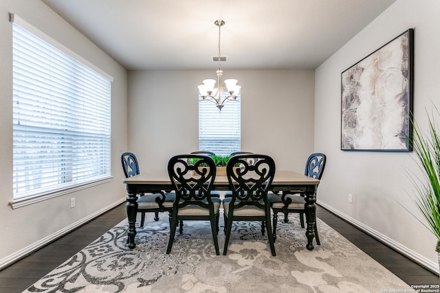 dining area with a chandelier, dark hardwood / wood-style floors, and plenty of natural light