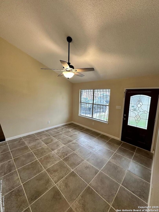 tiled foyer entrance featuring lofted ceiling, a textured ceiling, and ceiling fan