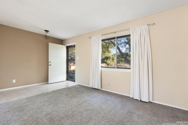 empty room featuring light colored carpet and a textured ceiling