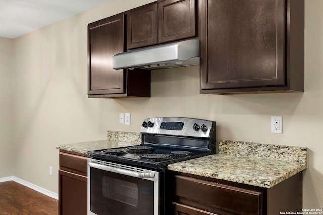 kitchen featuring stainless steel electric range oven, dark brown cabinets, dark hardwood / wood-style floors, and light stone countertops