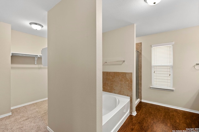 bathroom featuring independent shower and bath and hardwood / wood-style floors