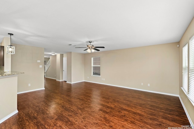 unfurnished living room featuring ceiling fan and dark hardwood / wood-style floors