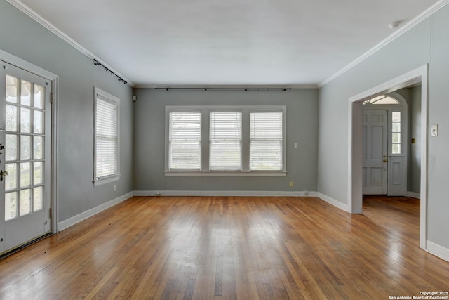 empty room with hardwood / wood-style flooring and ornamental molding