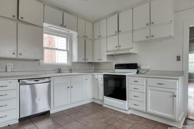 kitchen with electric range oven, tile patterned flooring, white cabinetry, sink, and stainless steel dishwasher