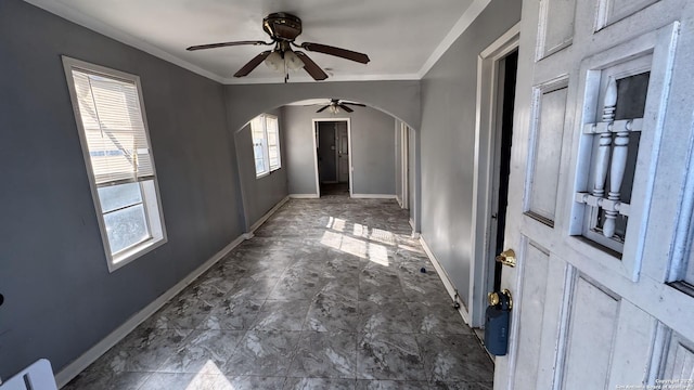 interior space featuring ceiling fan, a wealth of natural light, and crown molding