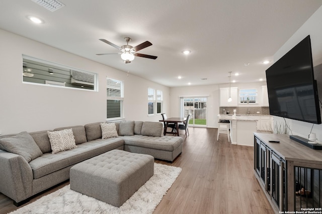 living room featuring light hardwood / wood-style floors and ceiling fan