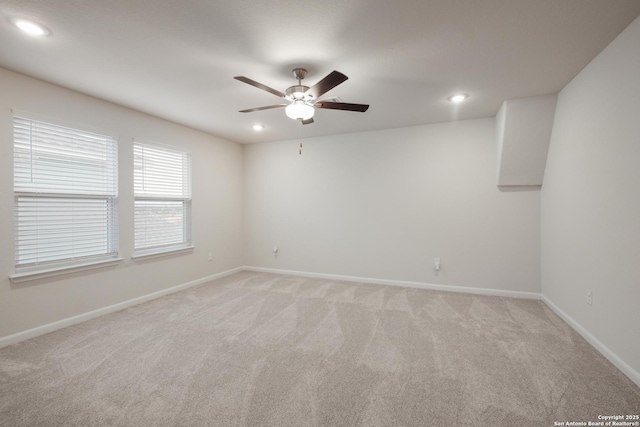 spare room featuring ceiling fan and light carpet