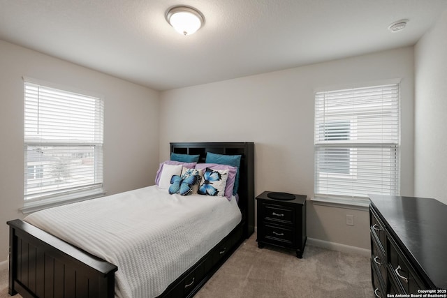 bedroom featuring light colored carpet and multiple windows