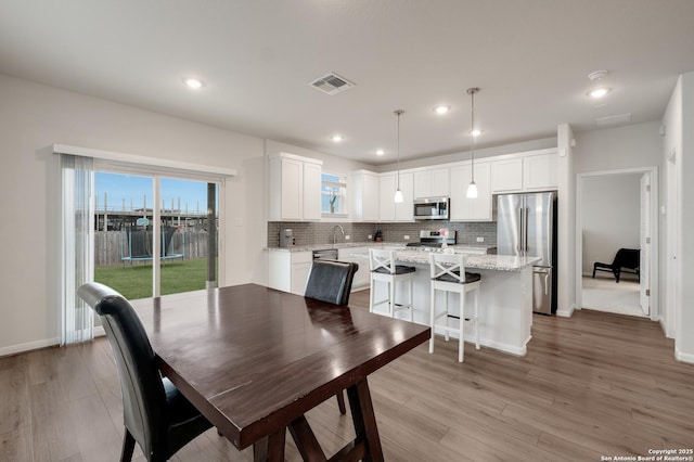 dining room featuring sink and light hardwood / wood-style flooring