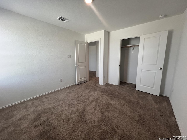 unfurnished bedroom with a closet and dark carpet