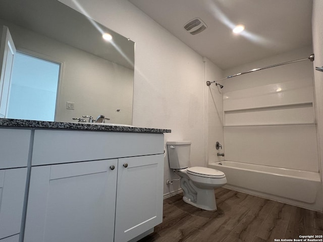 full bathroom featuring hardwood / wood-style flooring, toilet, vanity, and  shower combination